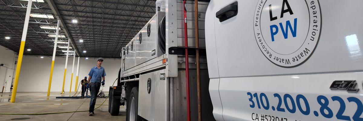 pressure washing company removes line stripes from concrete warehouse