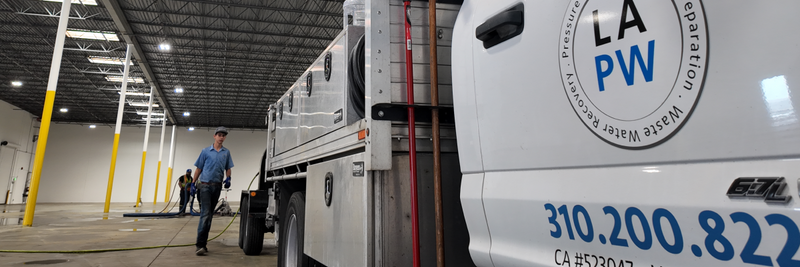 pressure washing company removes line stripes from concrete warehouse