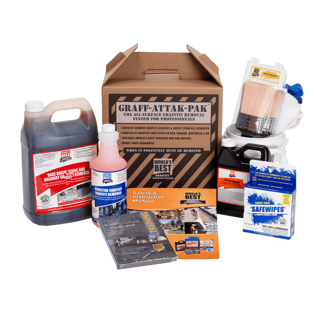 A comprehensive Graff-Attak-Pak graffiti removal system kit displayed on a clean white background. The kit includes a large jug of dark liquid, a pink bottle of cleaning solution, a cardboard box of safety gloves, a brush, a can of compressed air, a box of safety wipes, and an instruction manual.